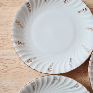 4 assiettes en porcelaine aux bordures et fleurs dorées